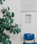 Outdoor Weatherproof Metal Junction Box Electrical Distribution Enclosure 160x300x200mm wall-mounted near a plant and chair