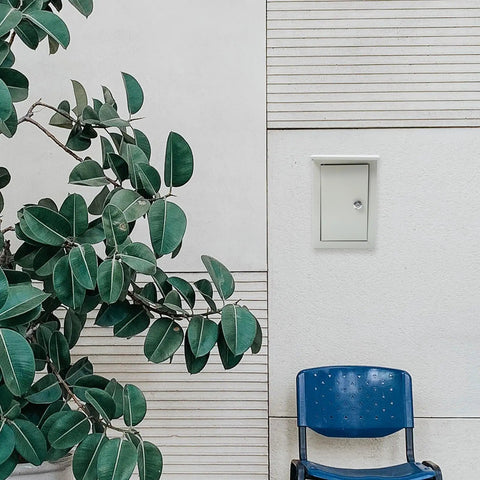 Outdoor Weatherproof Metal Junction Box Electrical Distribution Enclosure 160x300x200mm wall-mounted near a plant and chair