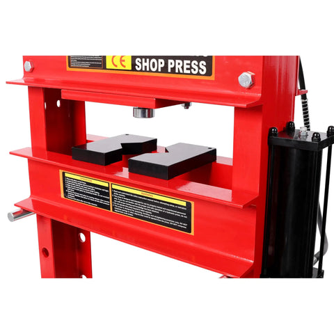 Close-up of Badass 30 Ton Hydraulic Shop Press H Frame with black plates, pressure gauge, and red steel frame for garage use.