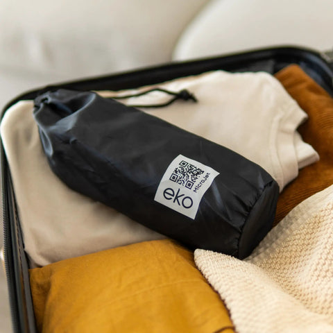 MicroJet MJ 450 Portable Bidet And Peri Bottle Sprayer For Travel in black travel bag on clothes in suitcase