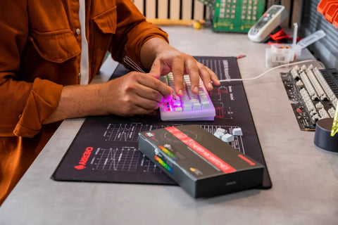 Mx2a Experience Box 10 Piece Mechanical Keyboard Switch Sample Tester For Diy Hot Swap Gaming Keyboards Explore And Test Different Variants Like Black Blue Brown Clear Top Ergo Clear Purple So You Can Find Your Vibe. hands testing switches on a compact keyboard