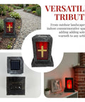 Red cemetery light with gold cross on black stand, versatile for indoor and outdoor memorial settings, solar panel detail.