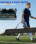 Person carrying portable 7 By 7 Ft Baseball And Softball Batting Net For Practice Hitting And Pitching with carry bag on field
