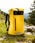 Yellow waterproof hiking backpack with PVC construction large capacity daypack in a scenic outdoor setting