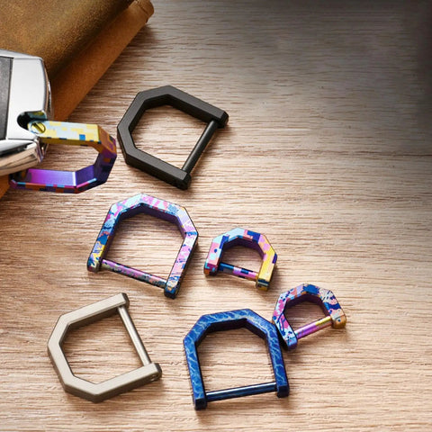 Various multicolor Alloy Miniature Keychain Clip With Detachable Tool And Screwdriver on a wooden surface.