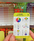 Person holding Color Card Deck For Creators Break Free From The Color Wheel with 200 Coordinated Cards showing hue charts.