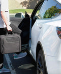 Man carrying XL MTG Bag For Magic The Gathering And Other TCG Accessories With Adjustable Interior Dividers near car