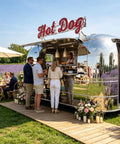 Slick Stainless Steel Food Trailer, 10 Ft Mobile Catering Cart With Mirror Finish serving hot dogs to customers in an outdoor setting.