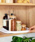 Rectangle Lazy Susan Turntable for Cabinets and Pantries, 360 Degree Spin Kitchen Organizer in use with spice jars on wooden shelf