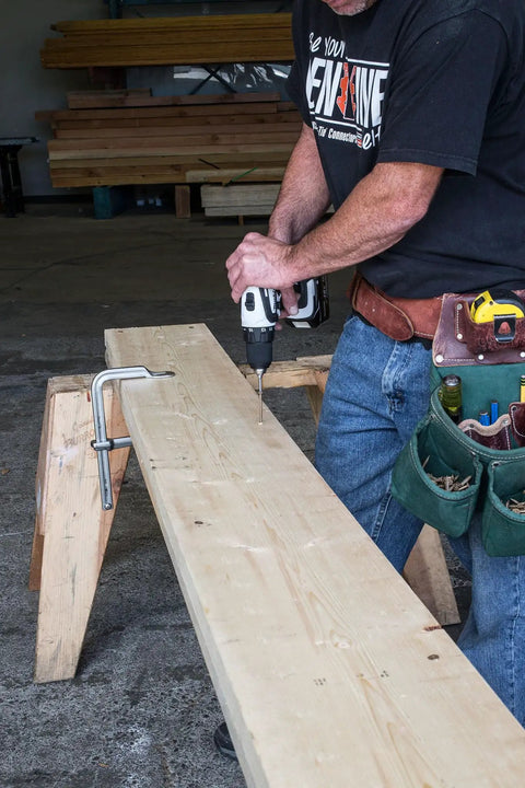 Dead Simple 4 Inch Framing Screws With Low Profile Head and Boss Level Sawtooth Point For Fast Track Wood Projects in use by a worker.