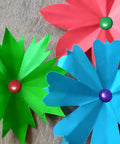 Assorted Color Round Head Craft Brads 200 Pack Top Tier Plated Metal Fasteners For Scrapbooking Reliable Document Stems. Green, blue, and pink paper flowers with brads.