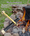 Compact Air Compression Fire Starter With Durable Metal Body next to campfire and cooking pot outdoors.