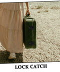 Person walking outside holding green suitcase secured with Retro Box Toggle Latch Padlock For Jewelry Boxes and Cabinets.