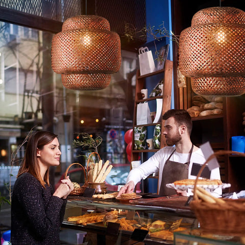 Hand Woven Bamboo Pendant Light 16 By 17 Inch Rattan Hanging Lamp With Wicker Basket Shades in a cozy cafe setting