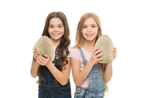 Two girls holding Jumbo Dino Egg Surprise With Twelve Collectible Dinosaurs Inside One Giant Easter Egg For Easter Gifts And Stem Learning Dig Up Jurassic Figures For Boys And Girls