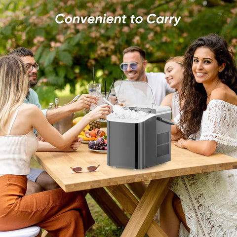 DUMOS countertop ice maker with handle; front view shows black compact unit with a clear lid and ice inside.