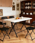 4 Pack Black Plastic Folding Chairs With Steel Frame For Outdoor Use No Fuss Portable Stackable Foldable Seating 350 Lb Capacity For Patio Garden Picnic Kitchen Events shown around a dining table in a kitchen setting