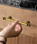 Hand reaching for Six Pack 3 Inch Hole Center Cabinet Pulls Antique Brass Zinc Alloy Drawer Handles for kitchen cabinets