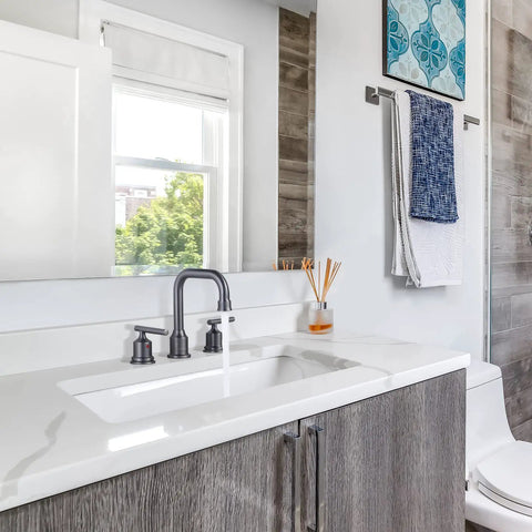 Dark Grey Widespread Brass Bathroom Faucet Set 3 Hole Vanity Tap With Drain And Supply Lines 2 Handle Basin Mixer Taps 3 Pieces Quick Install Fast Connect Durable Satin Finish For Modern Bathrooms installed on white vanity in bright bathroom.