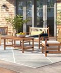 Outdoor patio set with wooden furniture and grey rug on a deck, featuring chairs and a table with potted plants and cushions.