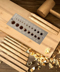 DIY Wood Dowel Plate Maker With Nineteen Hole Set In One Thirty Second Inch Increments, shown with wood shavings and mallet.