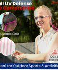 Woman wearing pink clear safety glasses with adjustable cord, ideal for outdoor sports, featuring anti-fog and scratch resistant lenses.