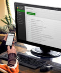 Person using computer and smartphone to access Bootable USB Repair Kit For Windows PCs with connected monitor and keyboard