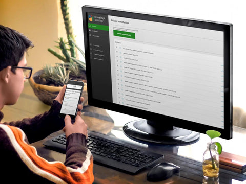 Person using computer and smartphone to access Bootable USB Repair Kit For Windows PCs with connected monitor and keyboard