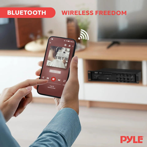 Person streaming music from phone to Beefy Bluetooth PA Mixing Amplifier 500W for home audio in living room setup.