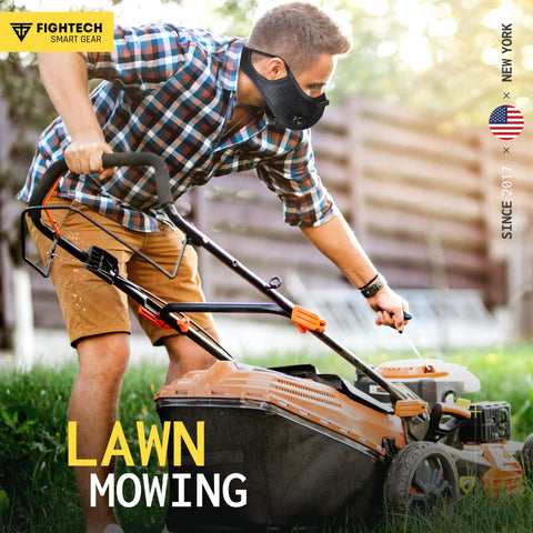 Man wearing Dust Face Mask With Extra Activated Carbon Filters And Air Valves For Woodworking mowing lawn with gas mower.