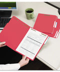 Person holding Letter Size Red Fastener Folders With Heavy Duty Embedded Straps And Assorted One Third Cut Tabs For Hustle Free Filing And Crisp Office Archiving Pack Of Fifty.