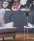 Modern black table lamp beside a gray armchair in a stylish living room with floral wallpaper