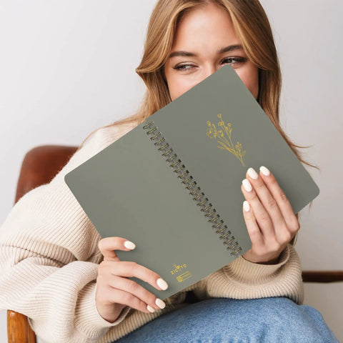 Woman holding a Stylish Aesthetic Spiral Notebook Set Of 3 For Women with Cute College Ruled 8x6 Journals, flower design cover visible.