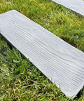 Wooden textured paver from Two Pack Walkway Path Maker DIY Concrete Molds Kit on grass for garden paths