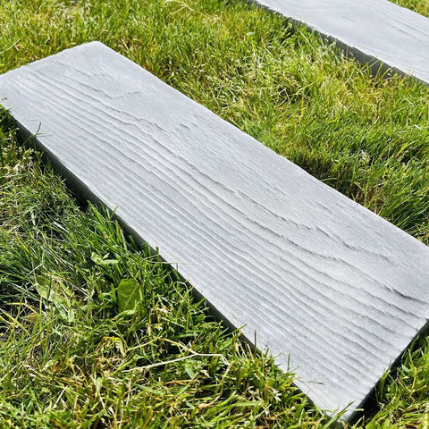 Wooden textured paver from Two Pack Walkway Path Maker DIY Concrete Molds Kit on grass for garden paths