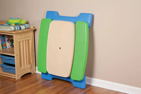 Six Seat Kids Picnic Table With Umbrella Multi Color folded against wall for easy storage in indoor setting