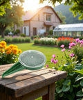 Adjustable Seed Dispenser Hand Tool For Garden Planting And Sowing on a wooden table with a garden in the background