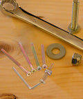 Close-up of Forty Nine Piece M6 Hex Drive Screws And Barrel Nuts Set with wrench on wooden surface, assorted lengths.