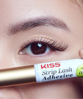 Close-up of eye with strip lashes, holding Clear Lash Adhesive For Strip Lashes And Lash Clusters, Waterproof All Day Hold, Latex Free With Aloe