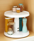 Game Changer Two Tier Height Adjustable Lazy Susan Turntable With Smooth 360 Swivel For Kitchen Cabinet And Pantry Organization And Quick Access Storage In White showcasing spices, containers, and bottles on a shelf.