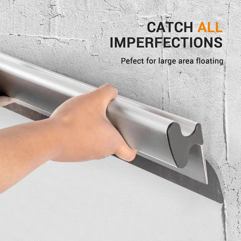 Hand holding Drywall Skimming Blade Set With 12, 22, And 32 Inch Blades In 0.35mm on wall, ergonomic aluminum grip visible.