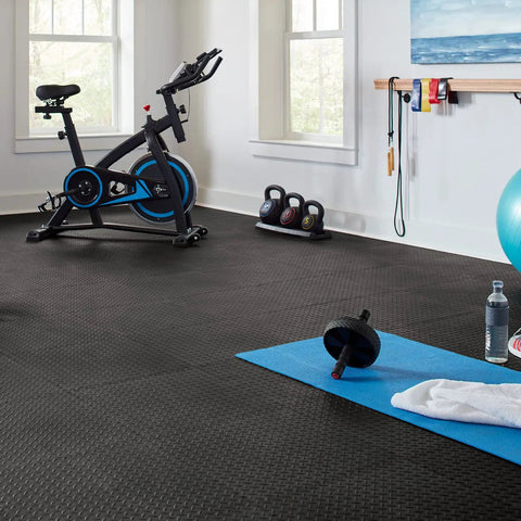 Interlocking Rubber Floor Tiles 18x18 Inch Diamond Plate Squares That Are Tough-As-Nails For Home Gym Garage Basement And Trade Show Floors, Durable Puncture-Resistant Mats, 24 Pack Black shown in gym setting with exercise equipment.