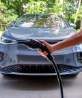 Dead Simple 16 Amp Level One Portable Ev Charger held near a grey electric vehicle, showcasing easy charging access.