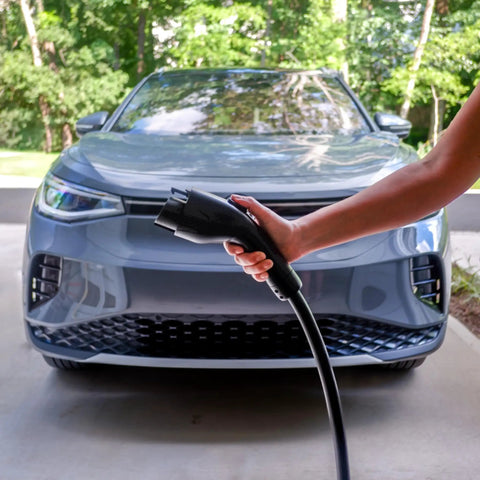 Dead Simple 16 Amp Level One Portable Ev Charger held near a grey electric vehicle, showcasing easy charging access.