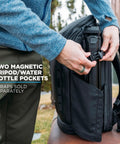 Person adjusting Camera Pack 25L With Ladder And Two Small Camera Cubes For DSLR Gear showing side magnetic pockets.