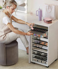 Woman using Rolling Storage Cart With 10 Large Clear Drawers, Mobile Makeup And Craft Organizer On Wheels in a beauty room.