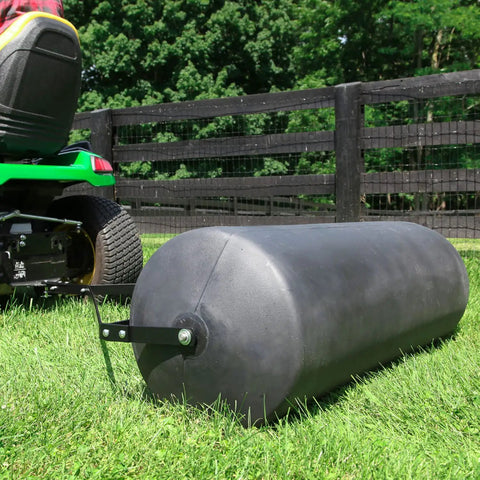 Tow Behind Poly Lawn Roller With Easy Turn Plug For Quick Fill And Dump 485 Lb Capacity being used with a riding mower