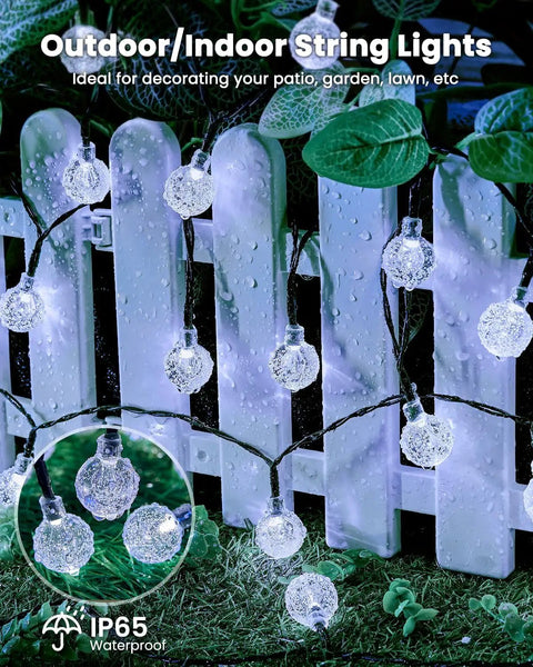 Close-up of 2-Pack 72 Ft Solar String Lights with 120 LEDs illuminating a white fence, showcasing waterproof feature for outdoor use.