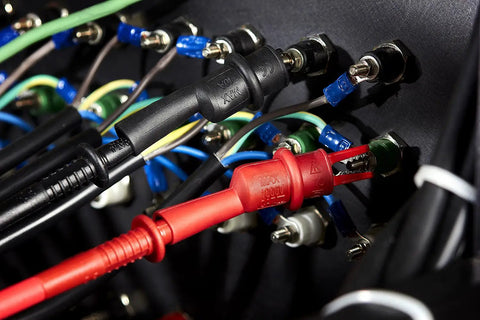 TL809 Electronic Test Lead Kit with dual alligator clips and removable insulators connected to electrical terminals.