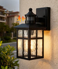 Built Different Matte Black Outdoor Wall Lights With Dusk To Dawn Motion Sensor And Water Glass Shade Waterproof Exterior Lantern mounted on wall.